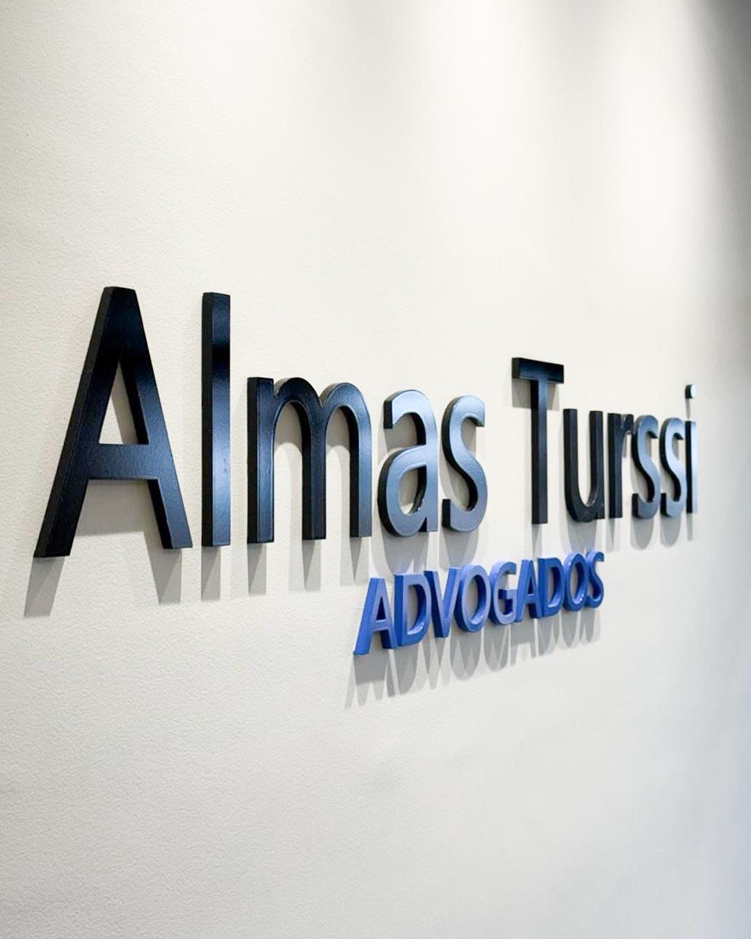 Logotipo Almas Turssi Advogados na parede do escritório